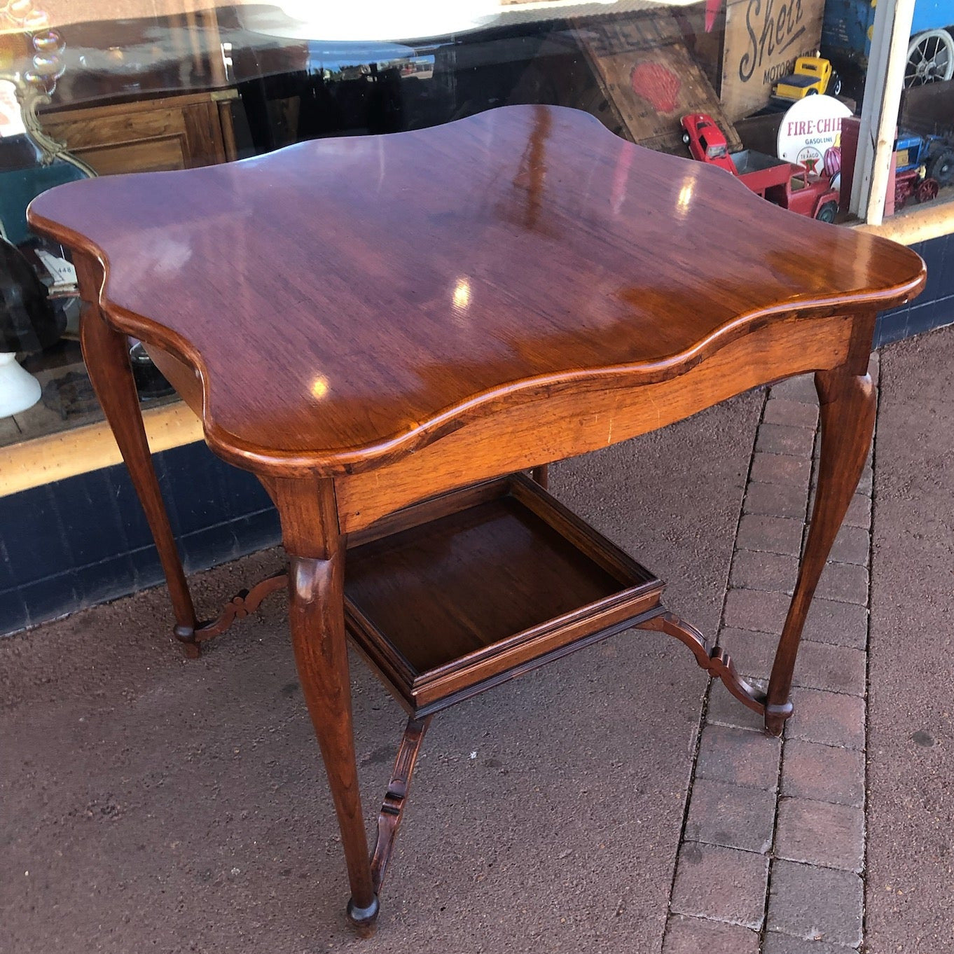 Wooden side table on a street with a store in the background