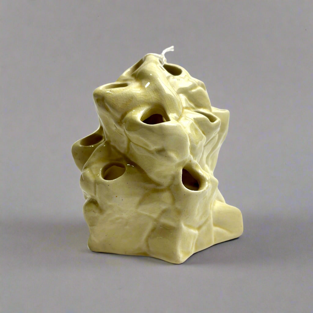 Ceramic candle holder with textured surface on a white background