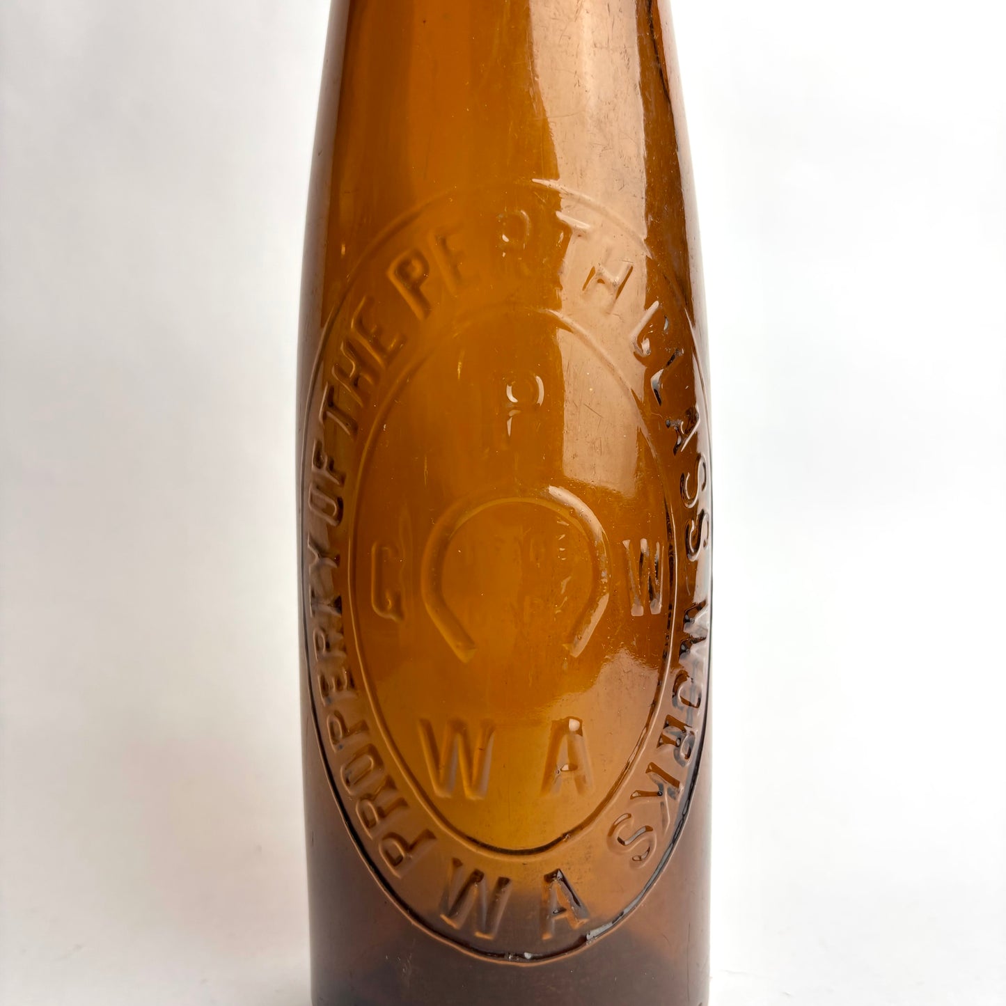Close-up of a brown bottle with a logo on a white background