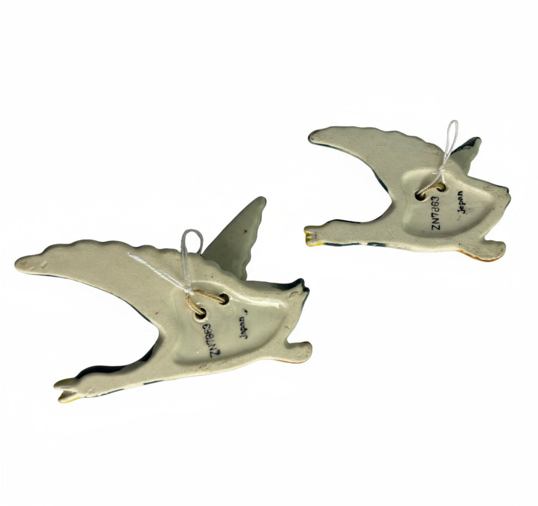 Two white ceramic animal figurines on a gray background