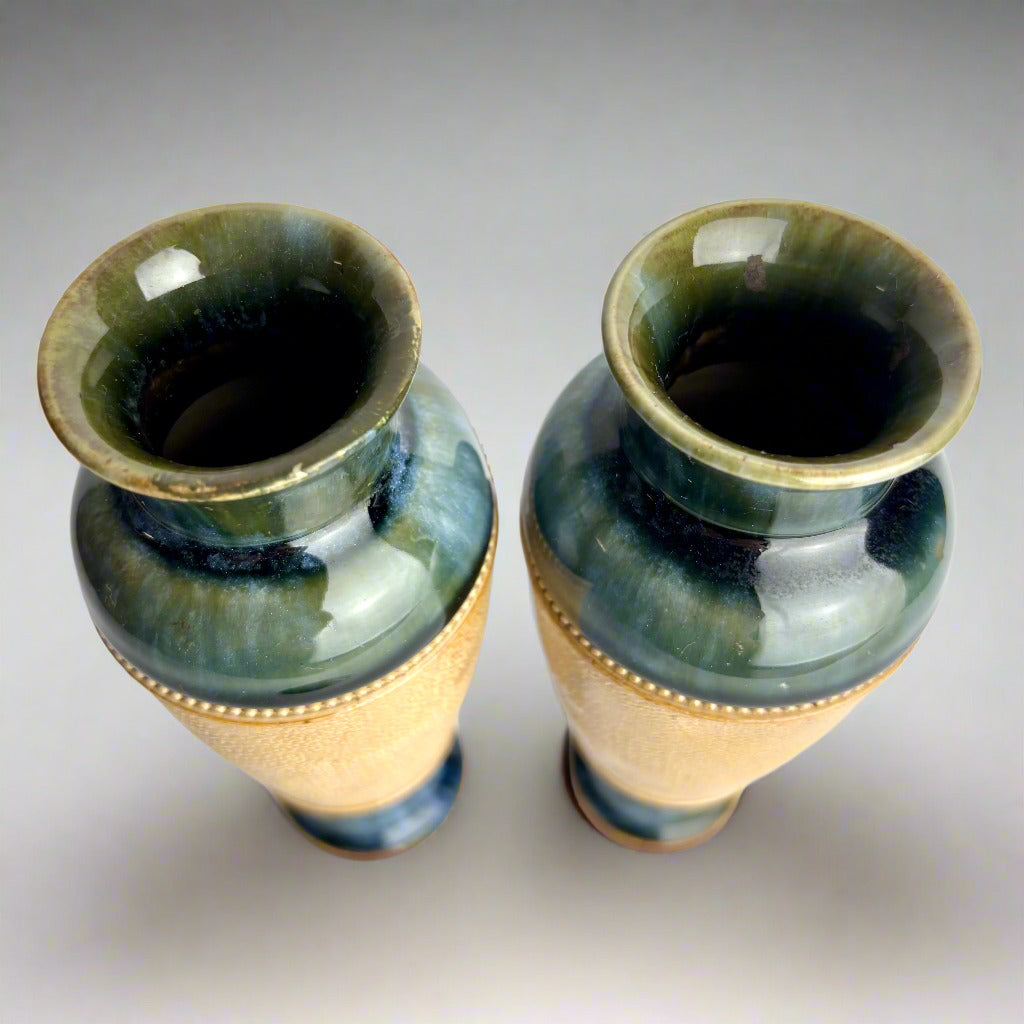 Two ceramic vases with green and gold glaze on a white background