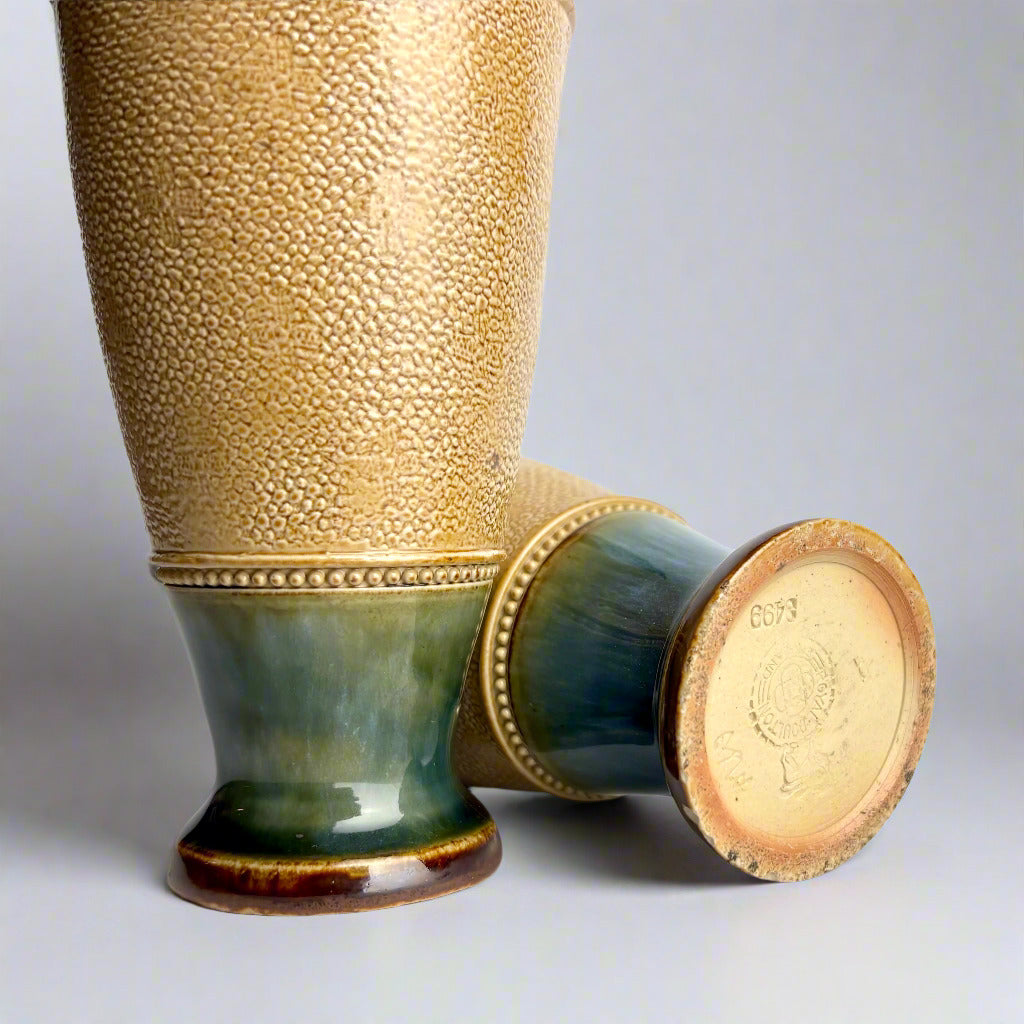 Ceramic vase with textured surface and green base on a light gray background
