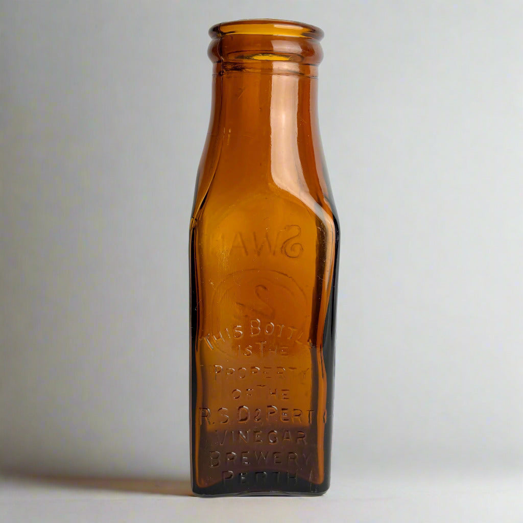 Brown glass bottle with embossed text on a white background