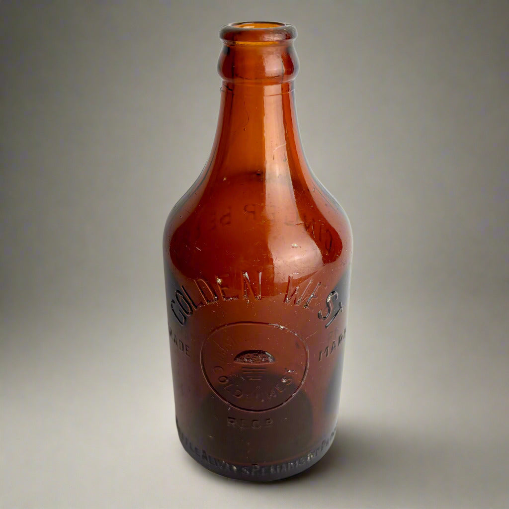 Brown glass bottle with embossed label on a white background