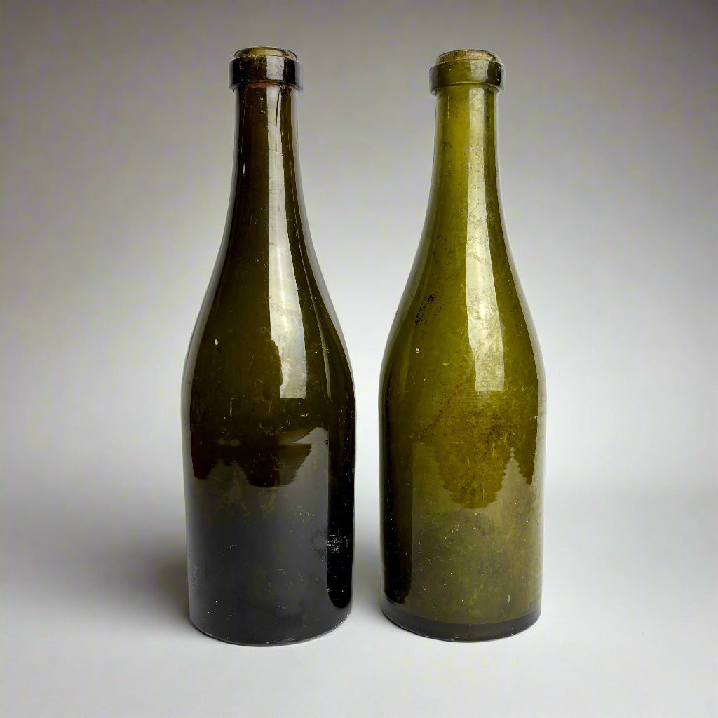 Two green glass bottles on a white background