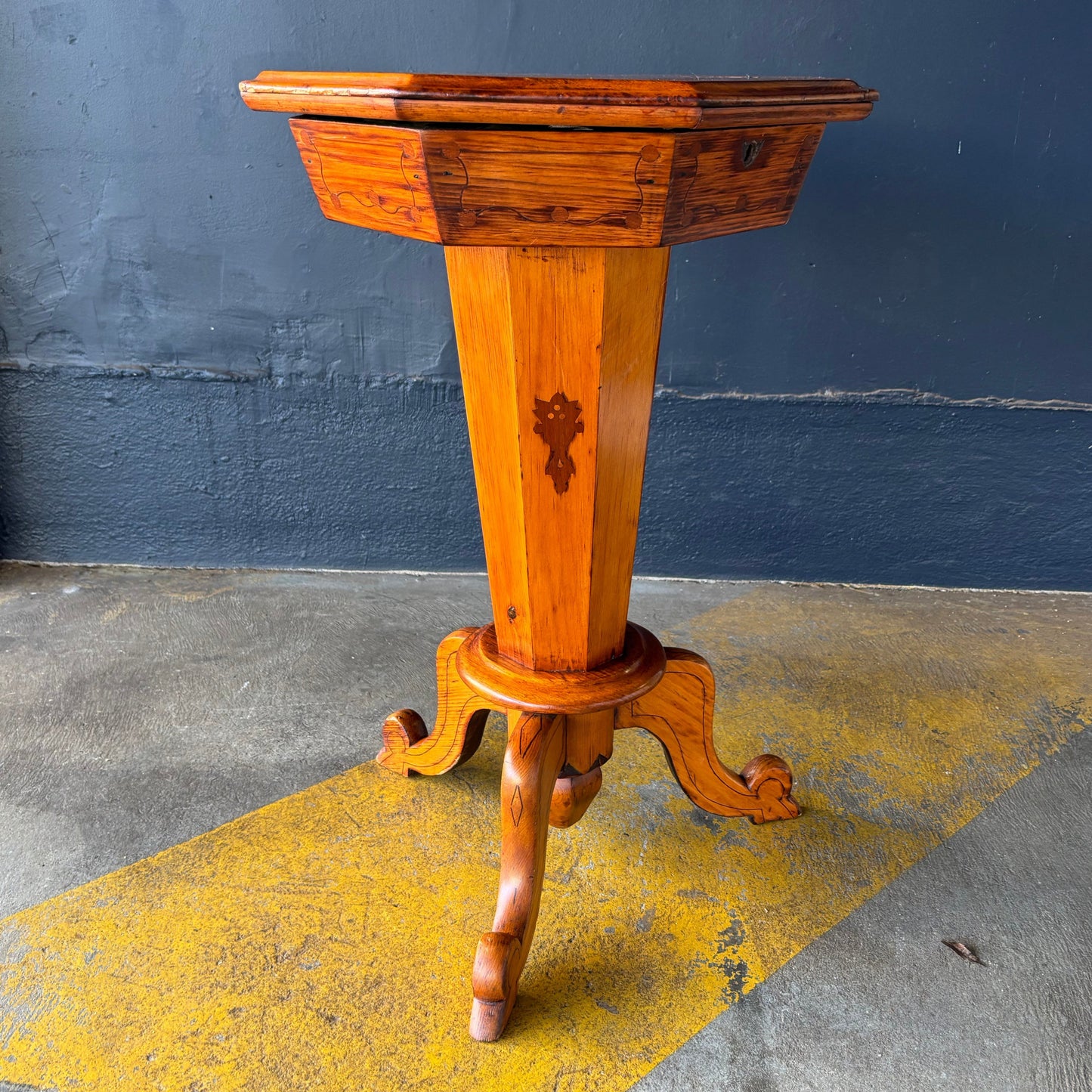 Wooden gaming and sewing table against a wall