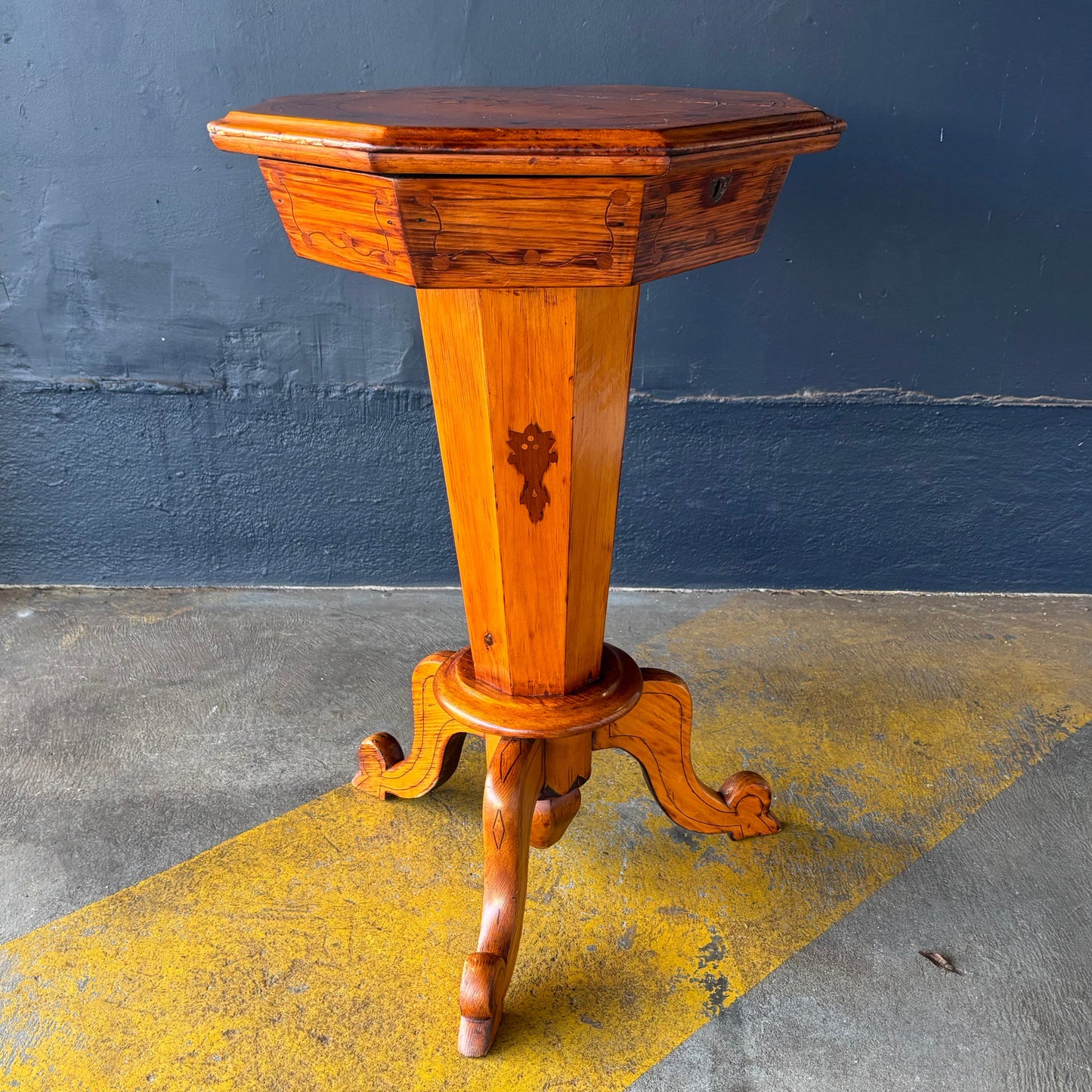 Wooden pedestal table against a blue wall