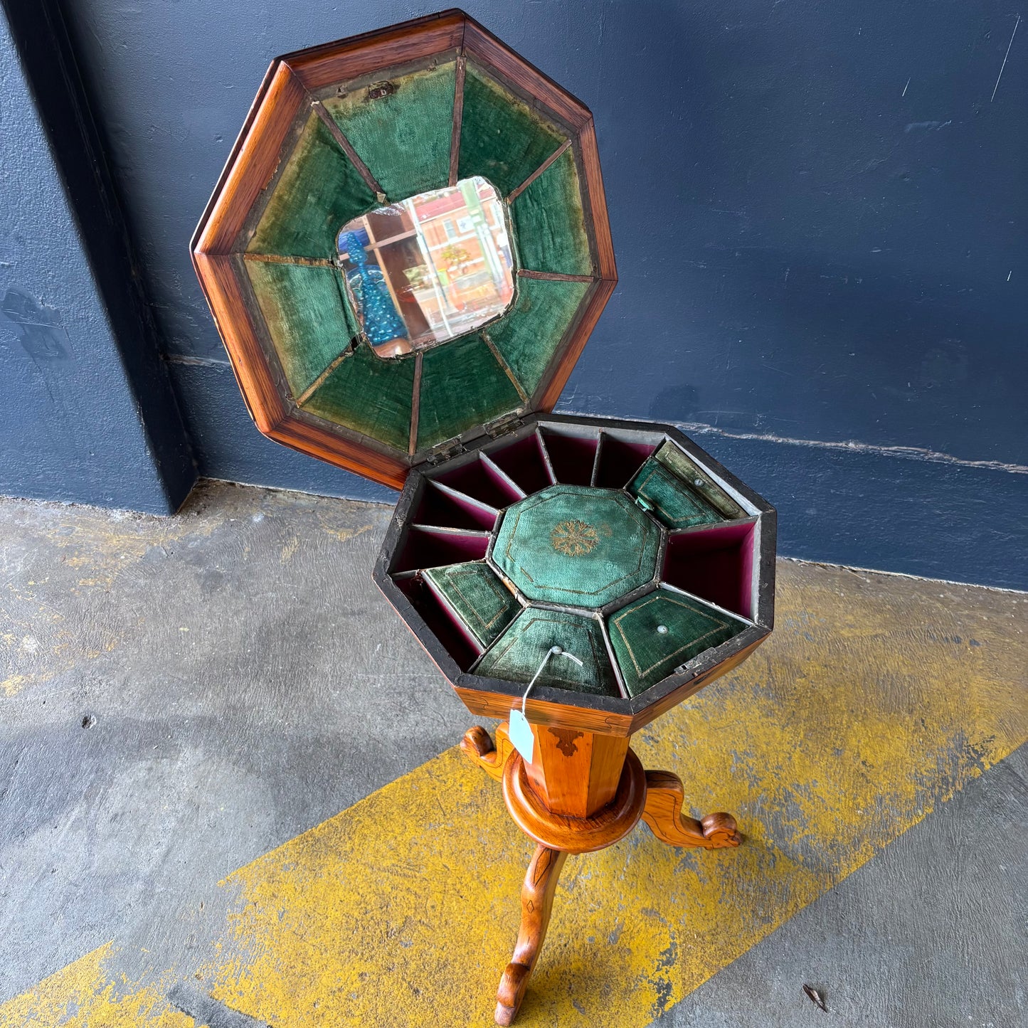 Hexagonal wooden object with stained glass panels on a dark surface