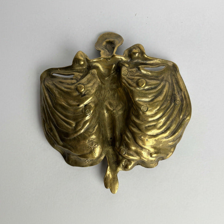 Bronze sculpture of two figures embracing on a white background