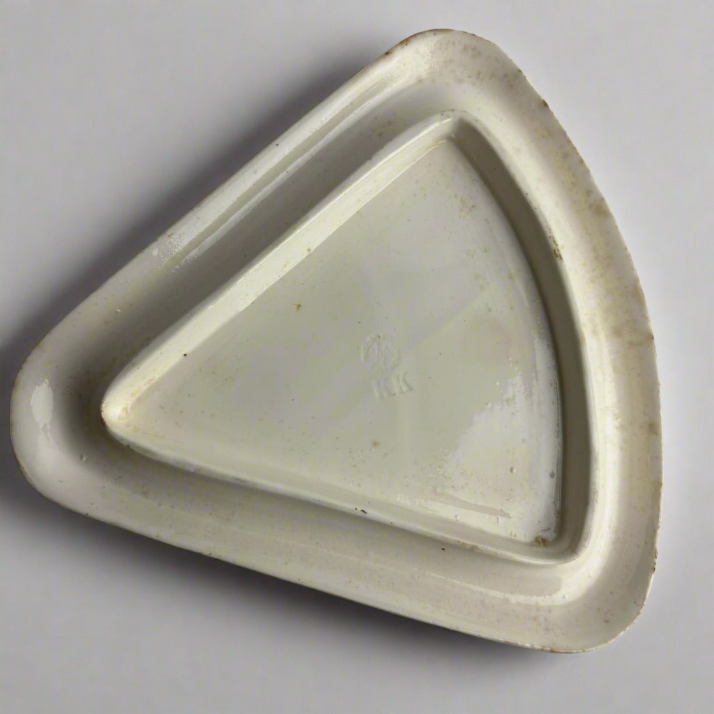 Triangular ceramic dish on a gray background