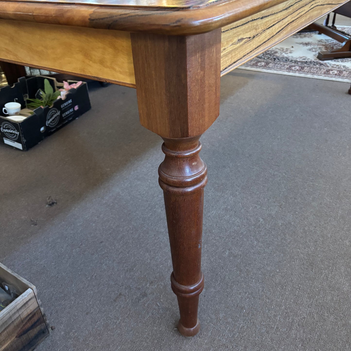 Wooden table leg on a carpeted floor