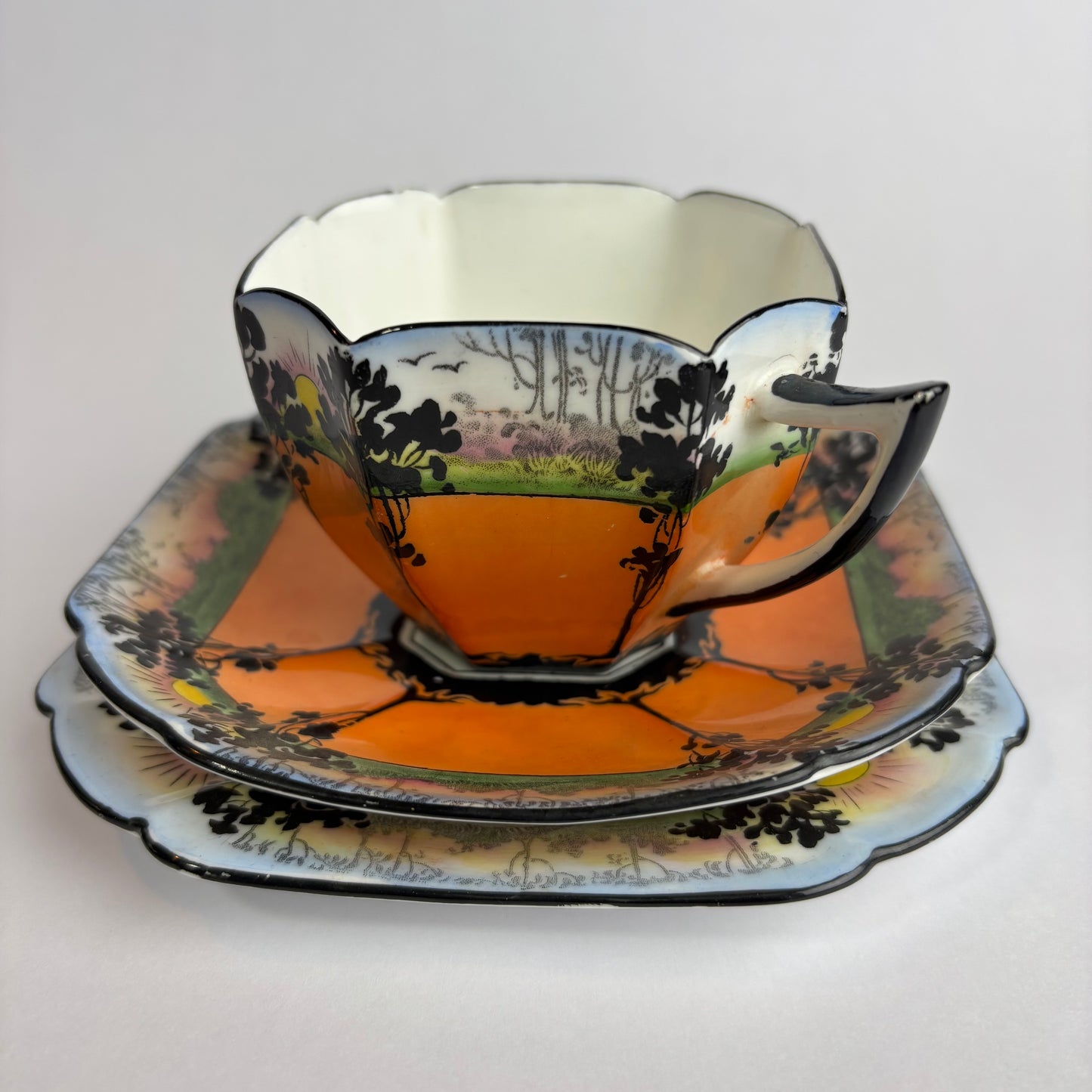 Decorative teacup and saucer with nature-themed design on a white background