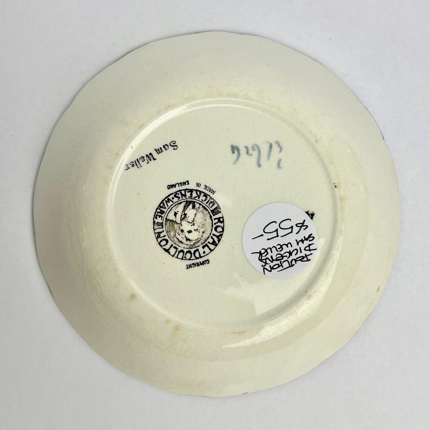 Back view of a ceramic plate with branding and text on a white background