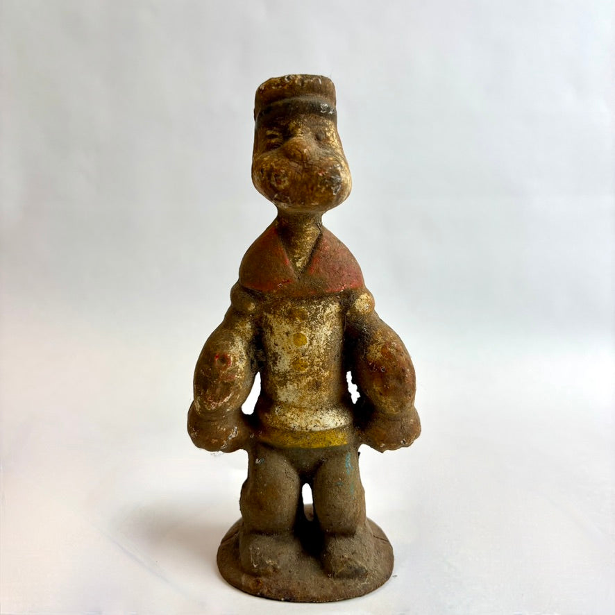 Vintage figurine of a person wearing a hat and jacket on a white background