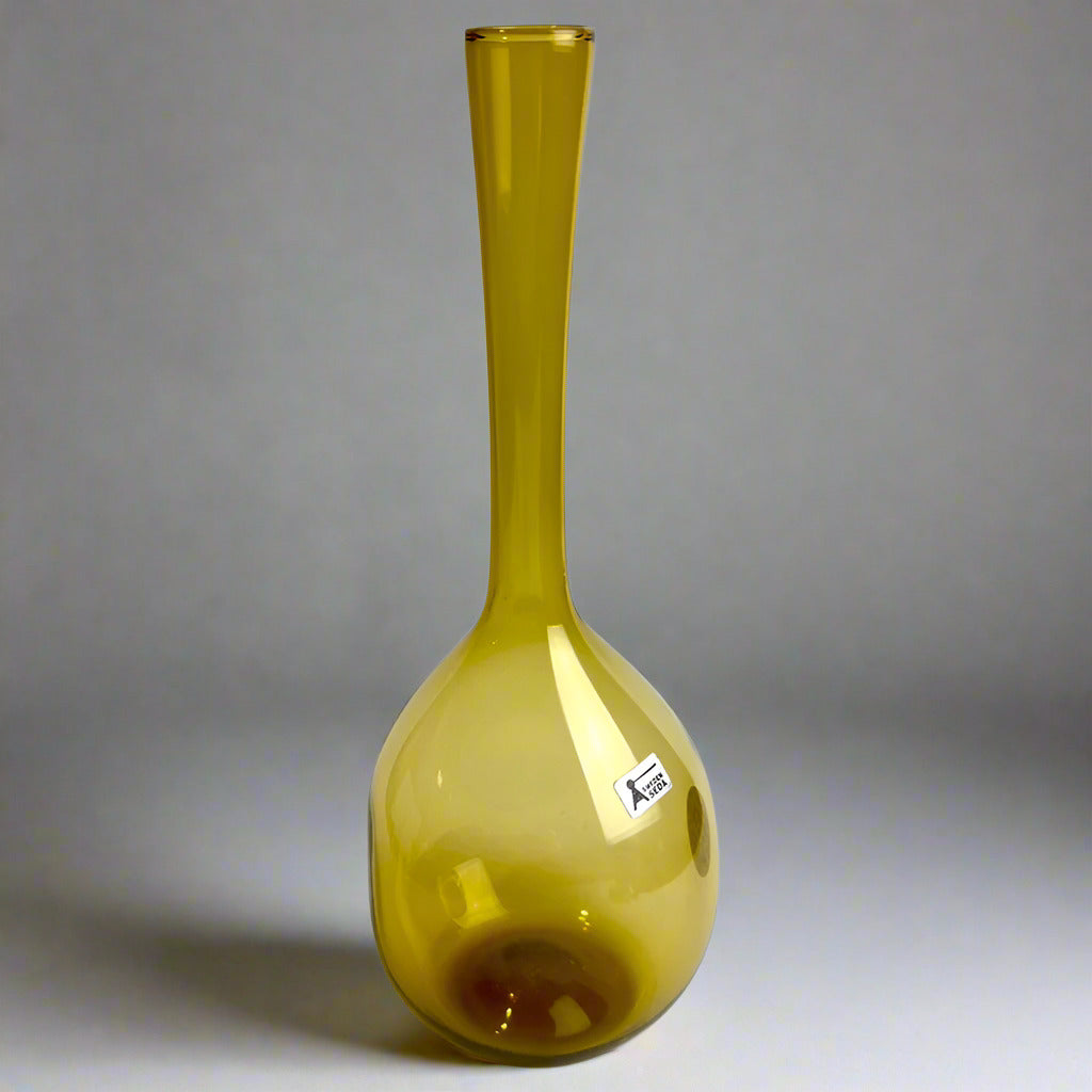Green glass bottle with a label on a white background
