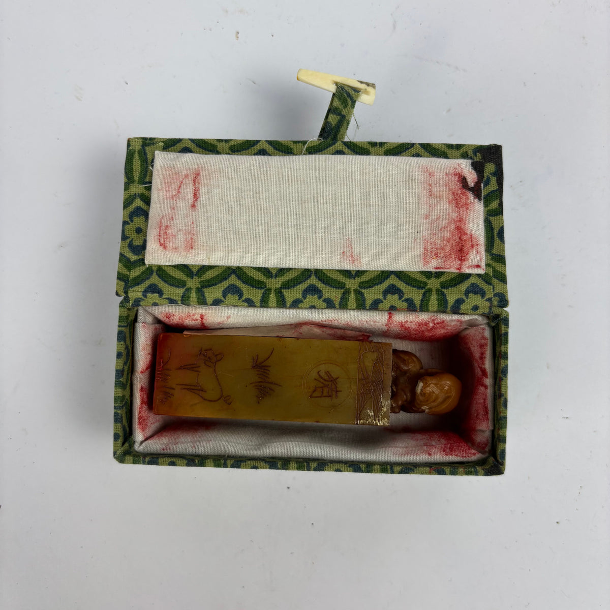 Chinese seal in brocade box showing stained white lining