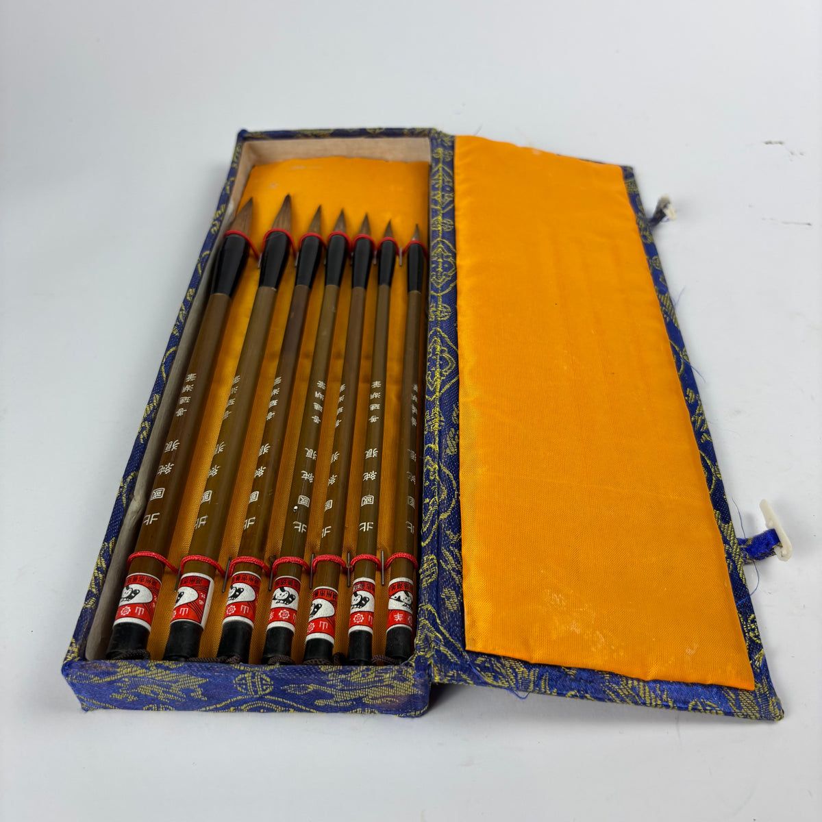 Seven Chinese calligraphy brushes in blue gold brocade case view 2