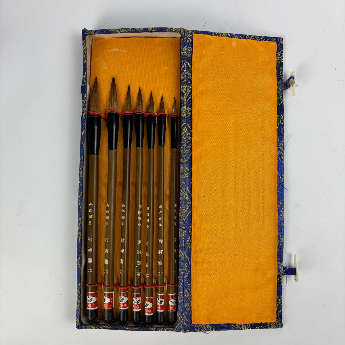 Seven Chinese calligraphy brushes in blue gold brocade case view 3