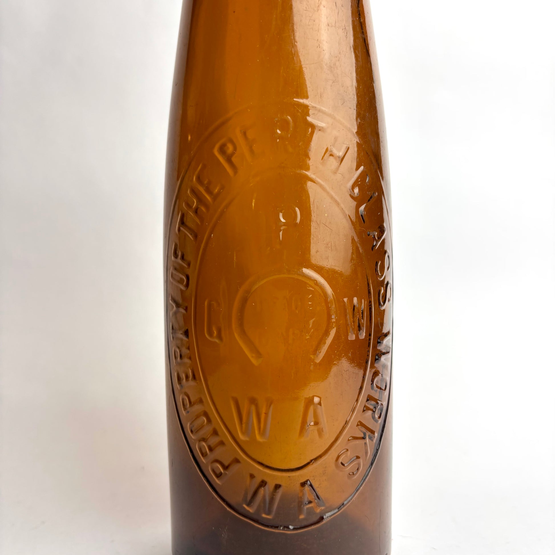 Close-up of a brown bottle with a logo on a white background