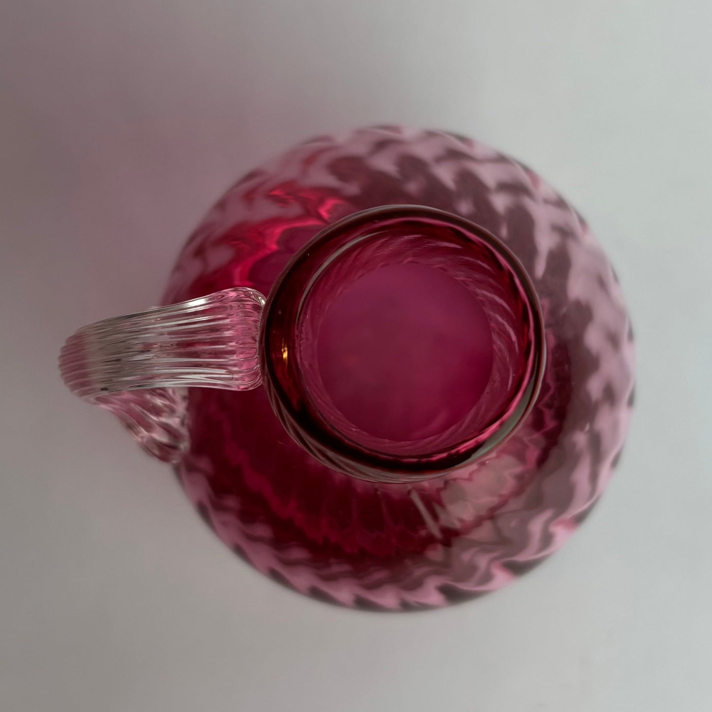 Pink glass pitcher on a white background