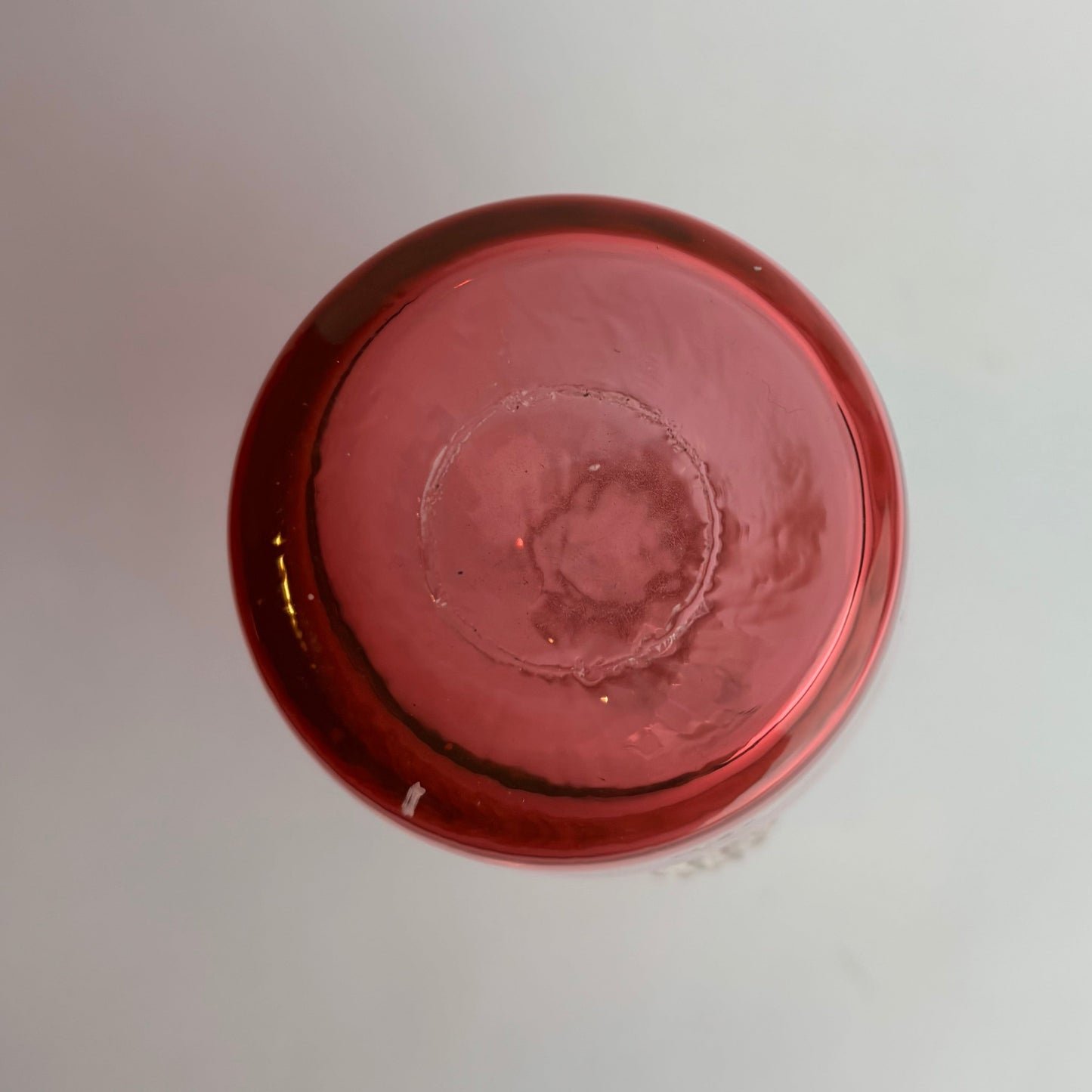 Close-up of a red metallic object on a light gray background