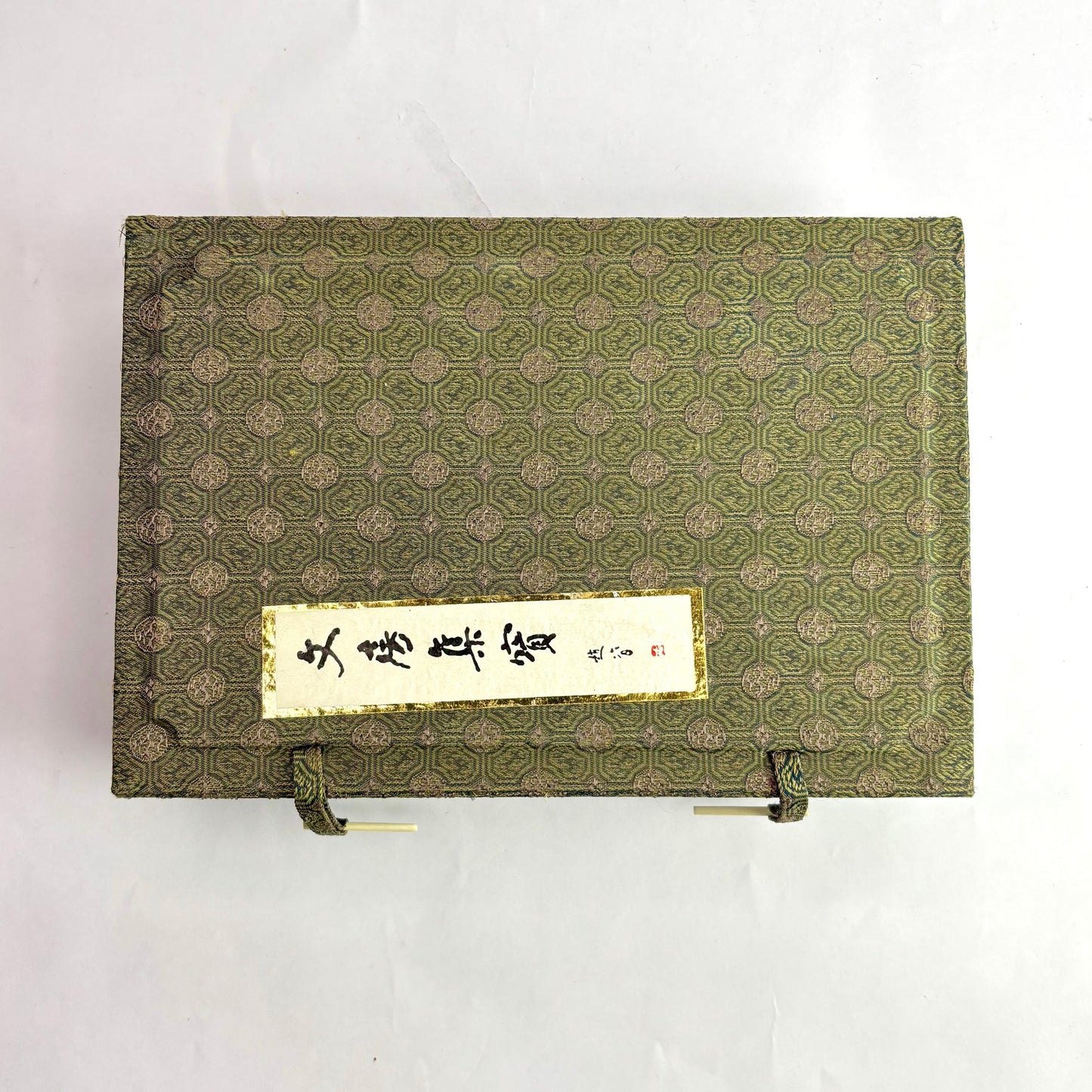 Decorative green box with a gold emblem on a white background