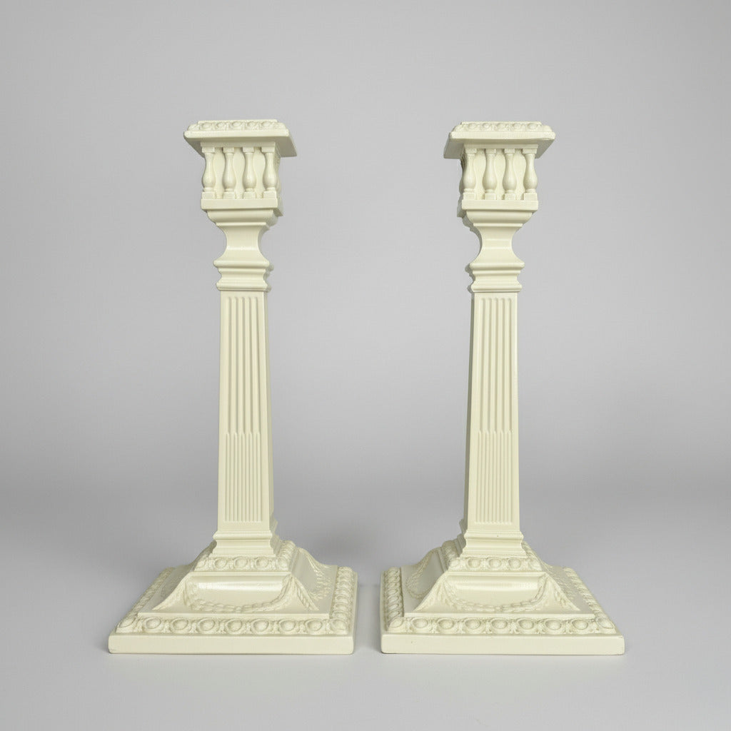 Two decorative columns with intricate designs on a gray background