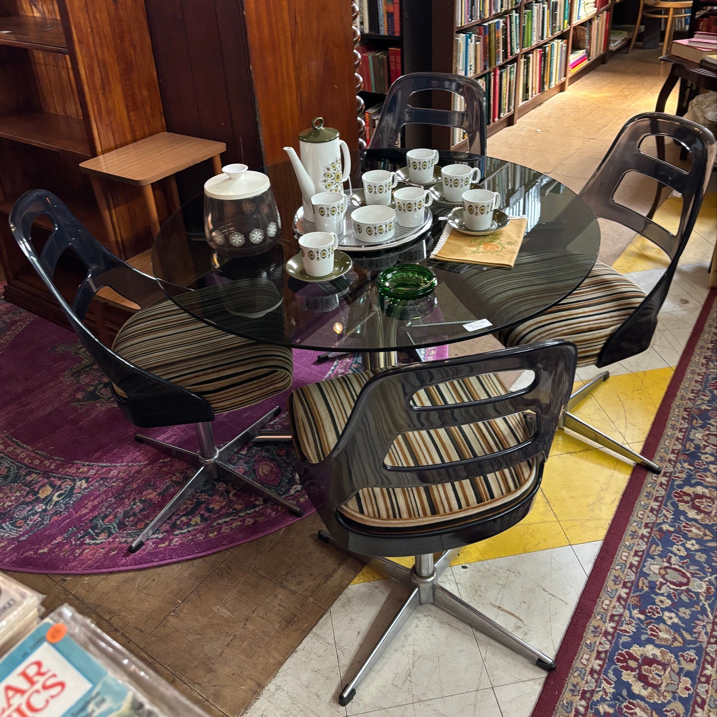 Dining table with chairs in a room filled with books