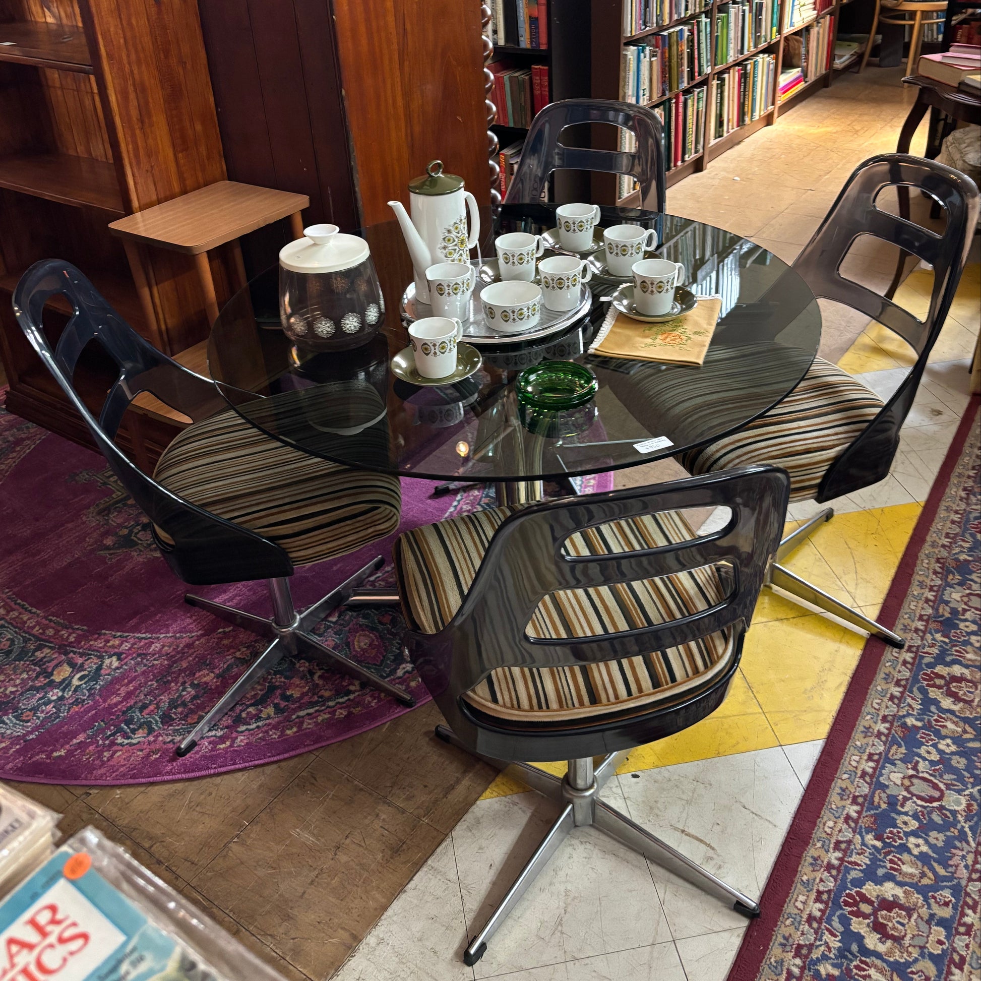 Dining table with chairs in a room filled with books
