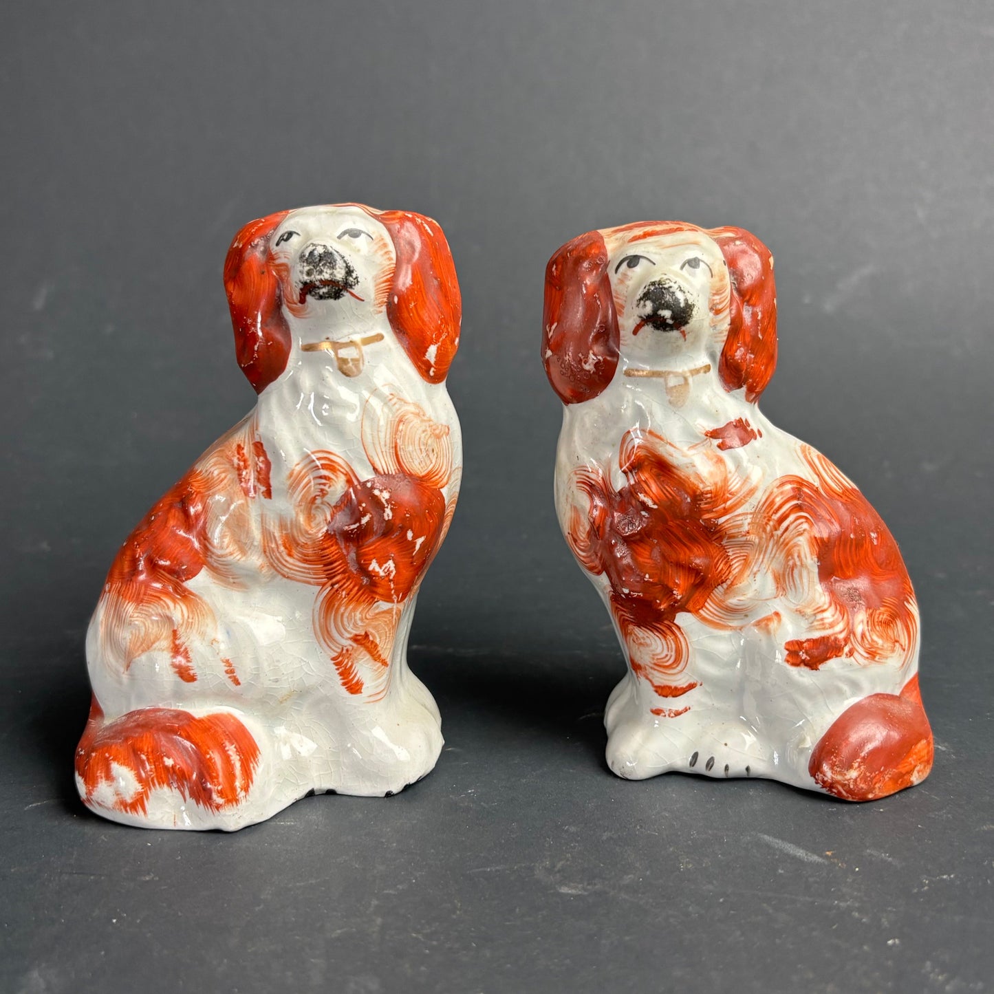 Two ceramic dog figurines on a gray background