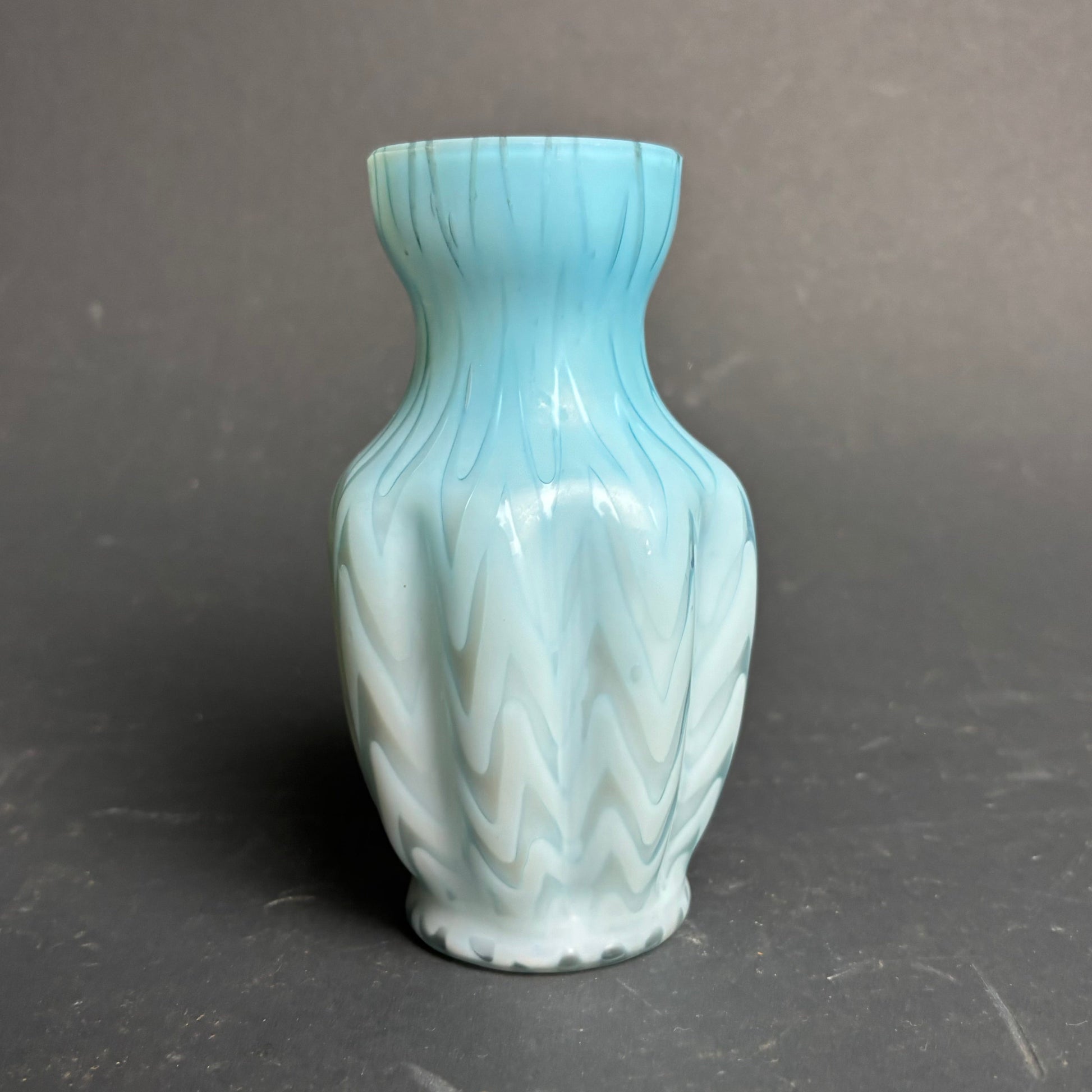 Light blue ceramic vase with textured design on a gray background