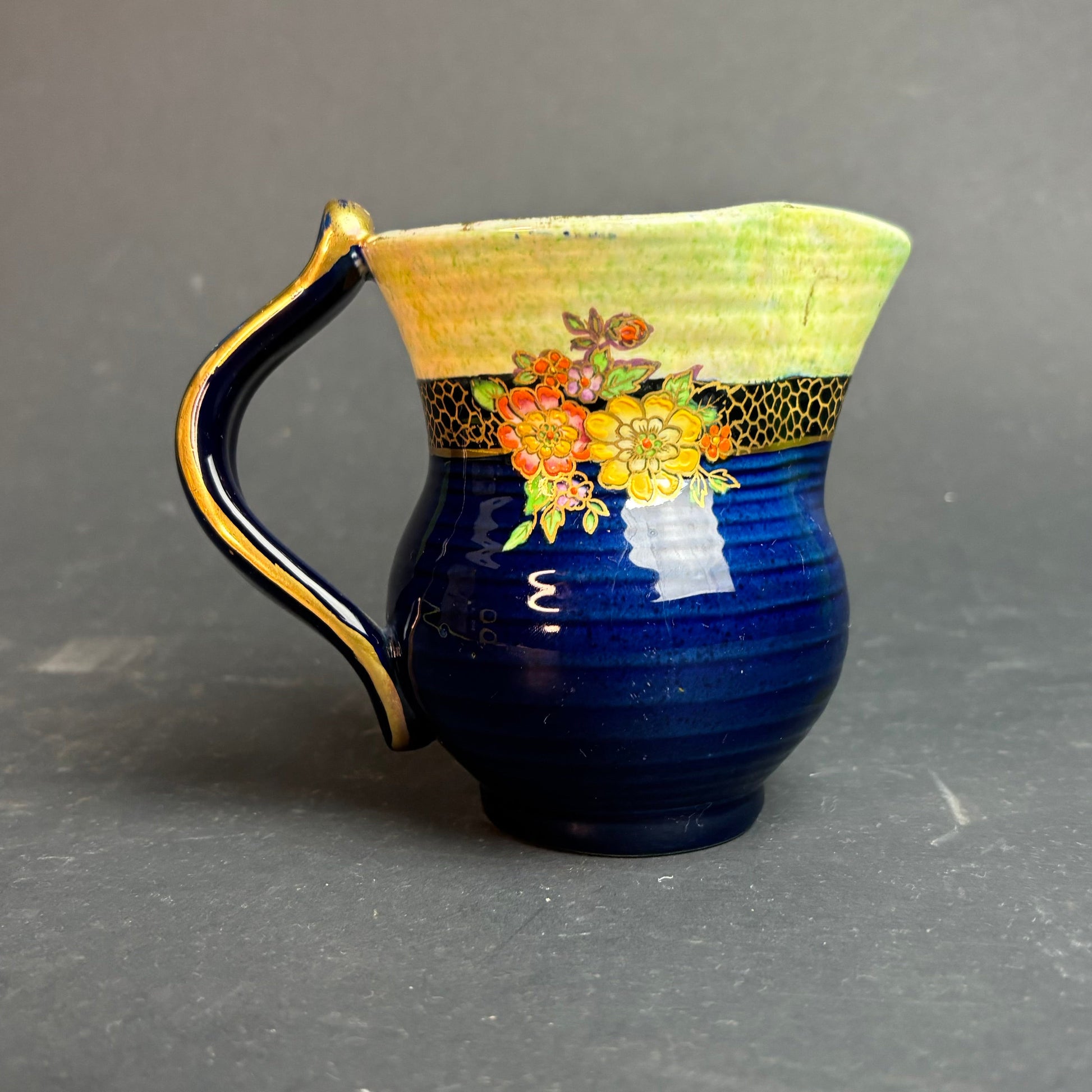 Ceramic pitcher with floral design on a gray background