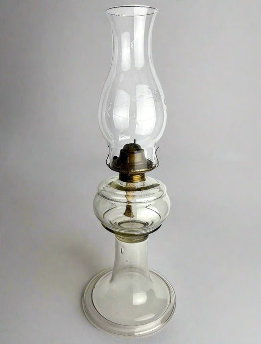 Clear glass oil lamp on a white background