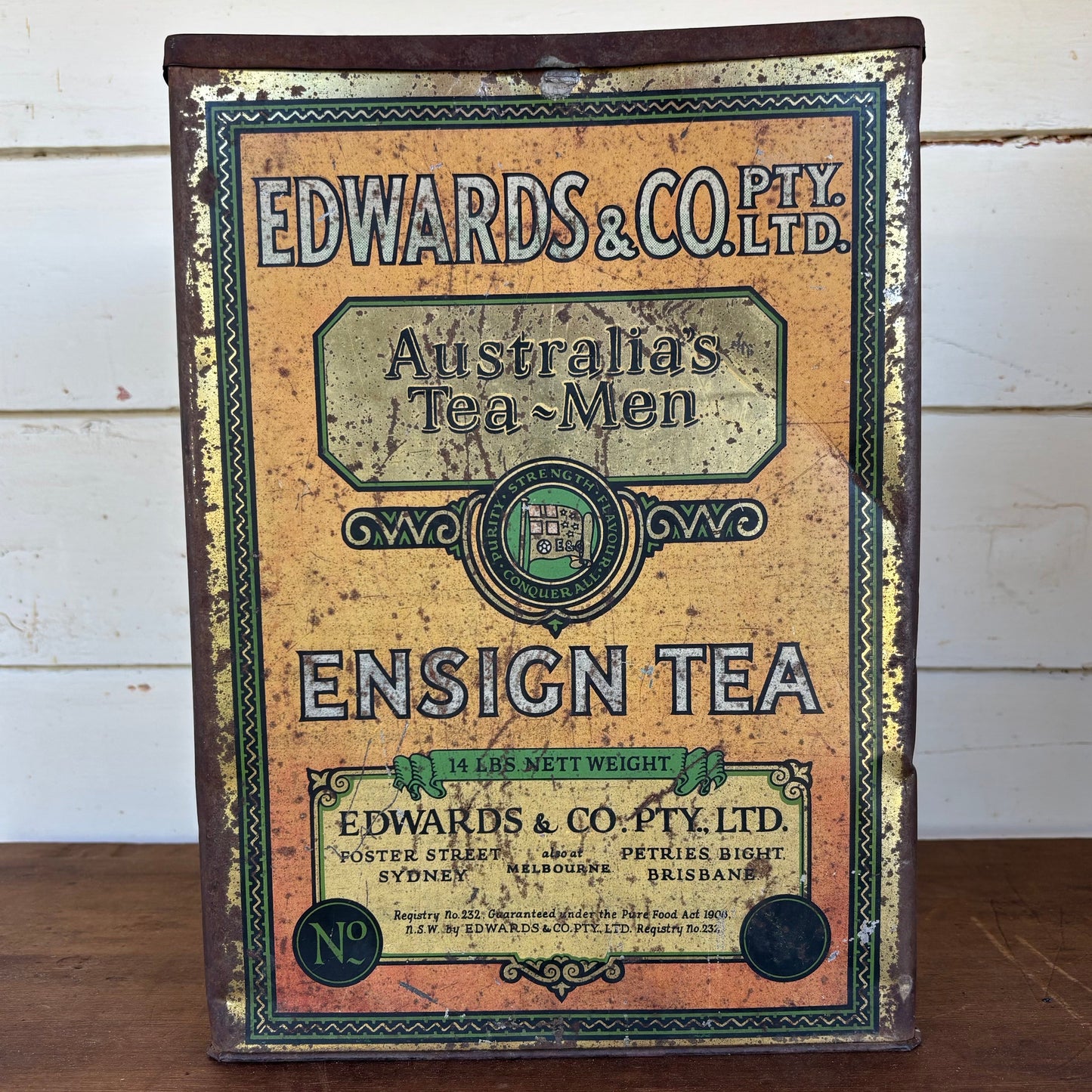 Vintage tea canister with 'Edwards & Co. Pty. Ltd.' branding on a wooden surface.