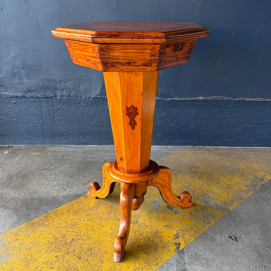 Wooden pedestal table against a blue wall