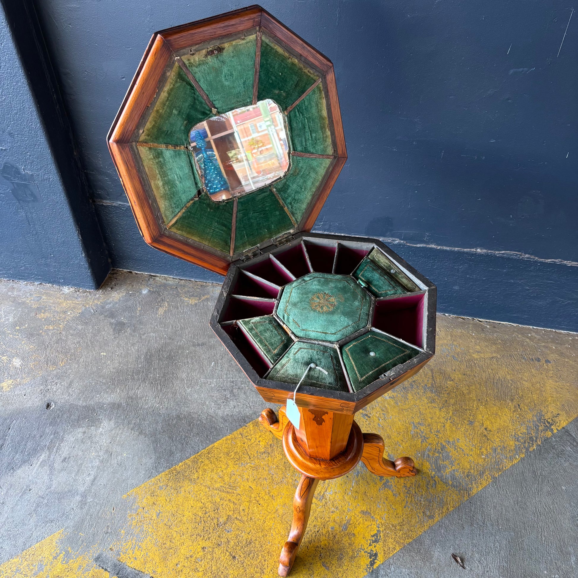 Hexagonal wooden object with stained glass panels on a dark surface
