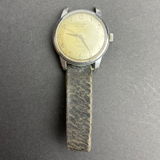 Vintage wristwatch with a leather strap on a gray background