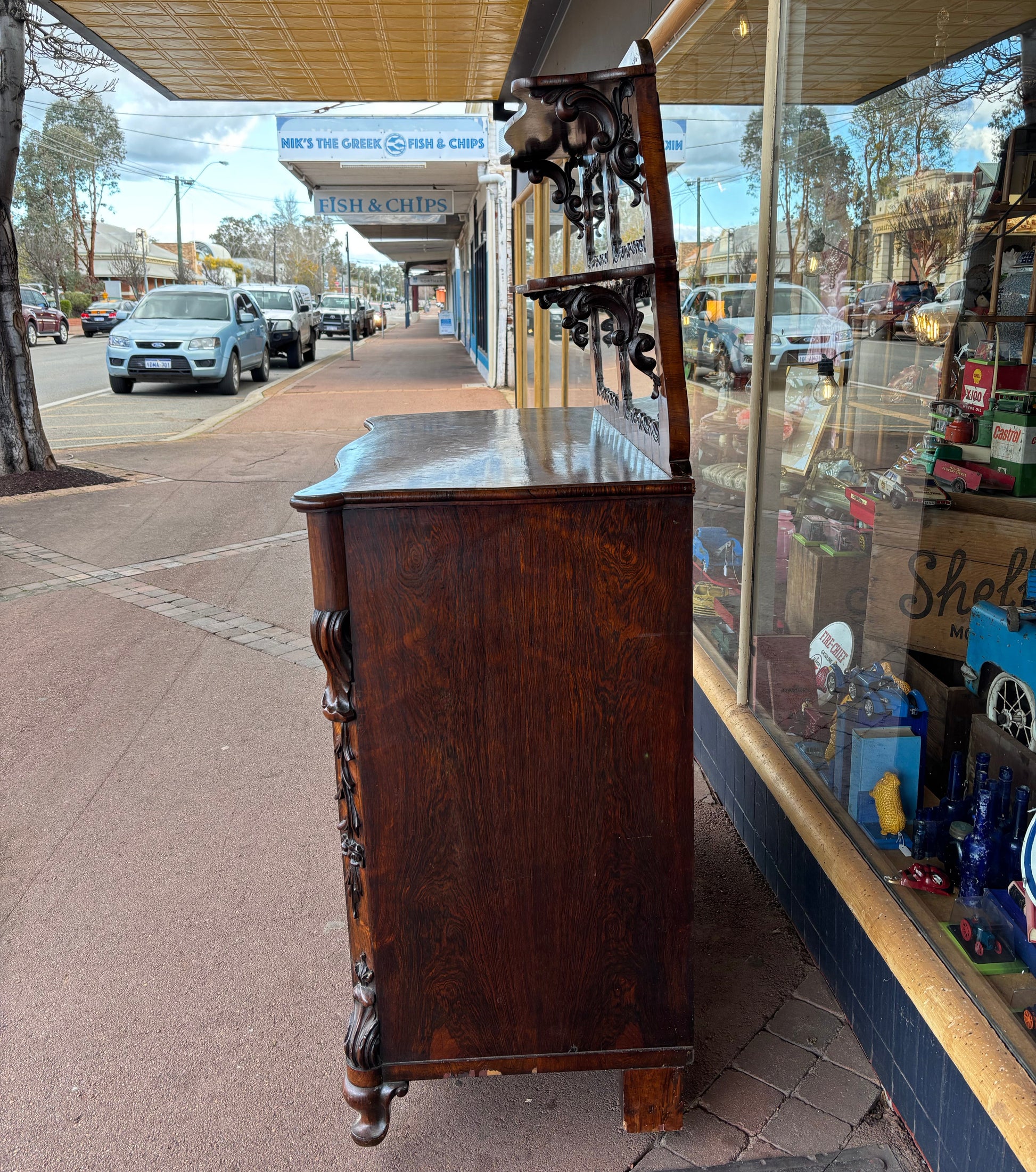 Wooden shelf with decorative items on a reflective surface