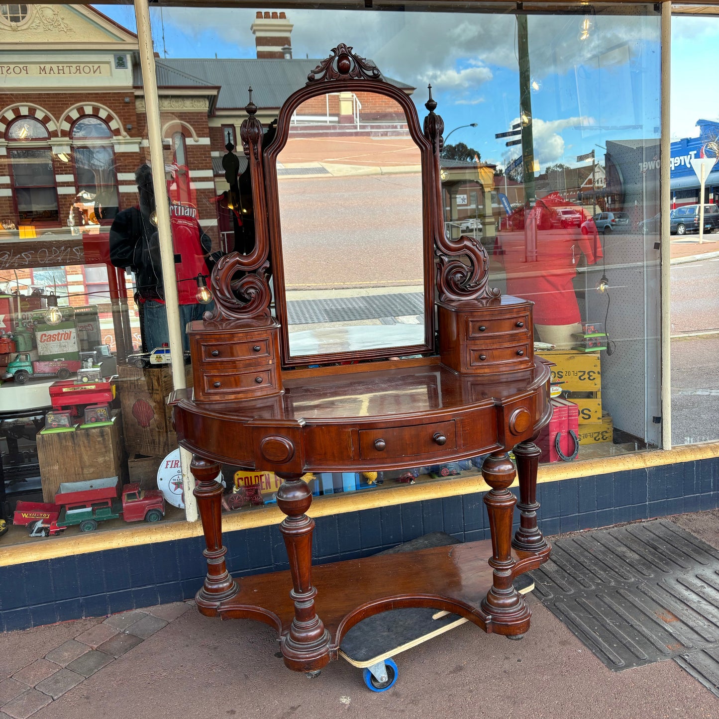 Vintage wooden desk with mirror in front of a store window