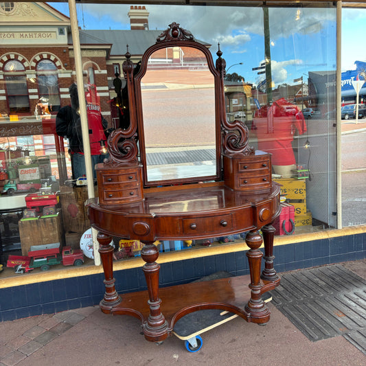 Vintage wooden desk with mirror in front of a store window