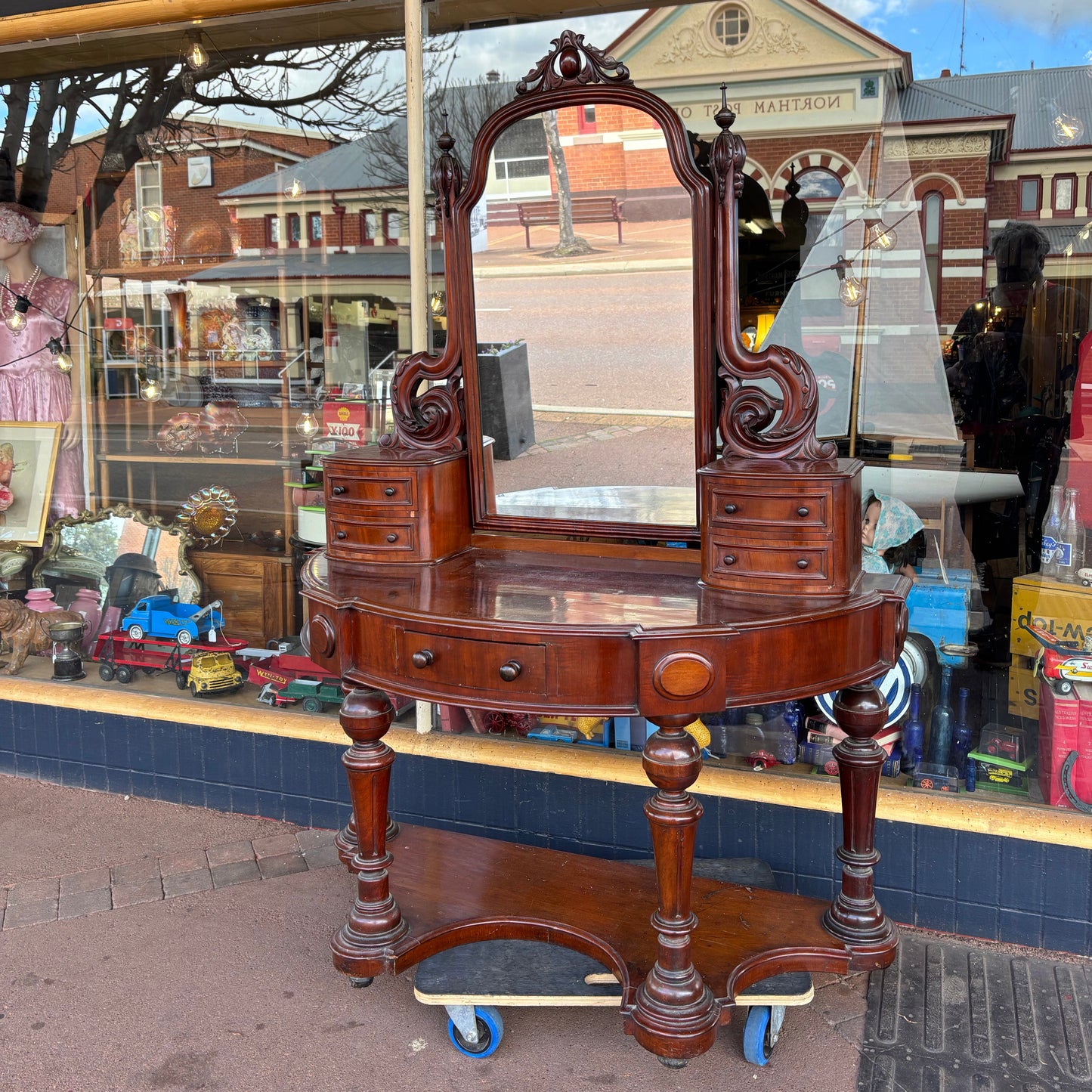 Wooden sideboard with decorative elements on a reflective surface