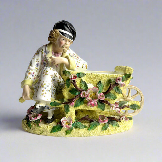 Porcelain figurine of a woman with a child on a cart with floral decorations on a white background