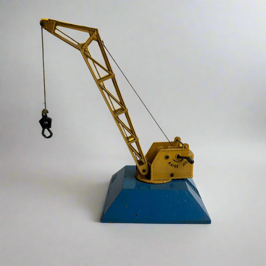 Model crane on a blue base against a white background