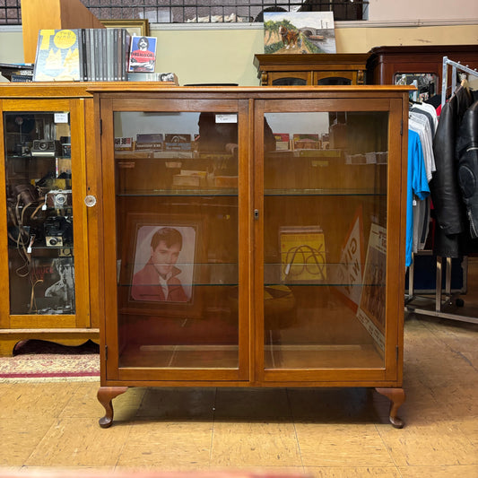 Wooden bookshelf with glass doors in a room setting