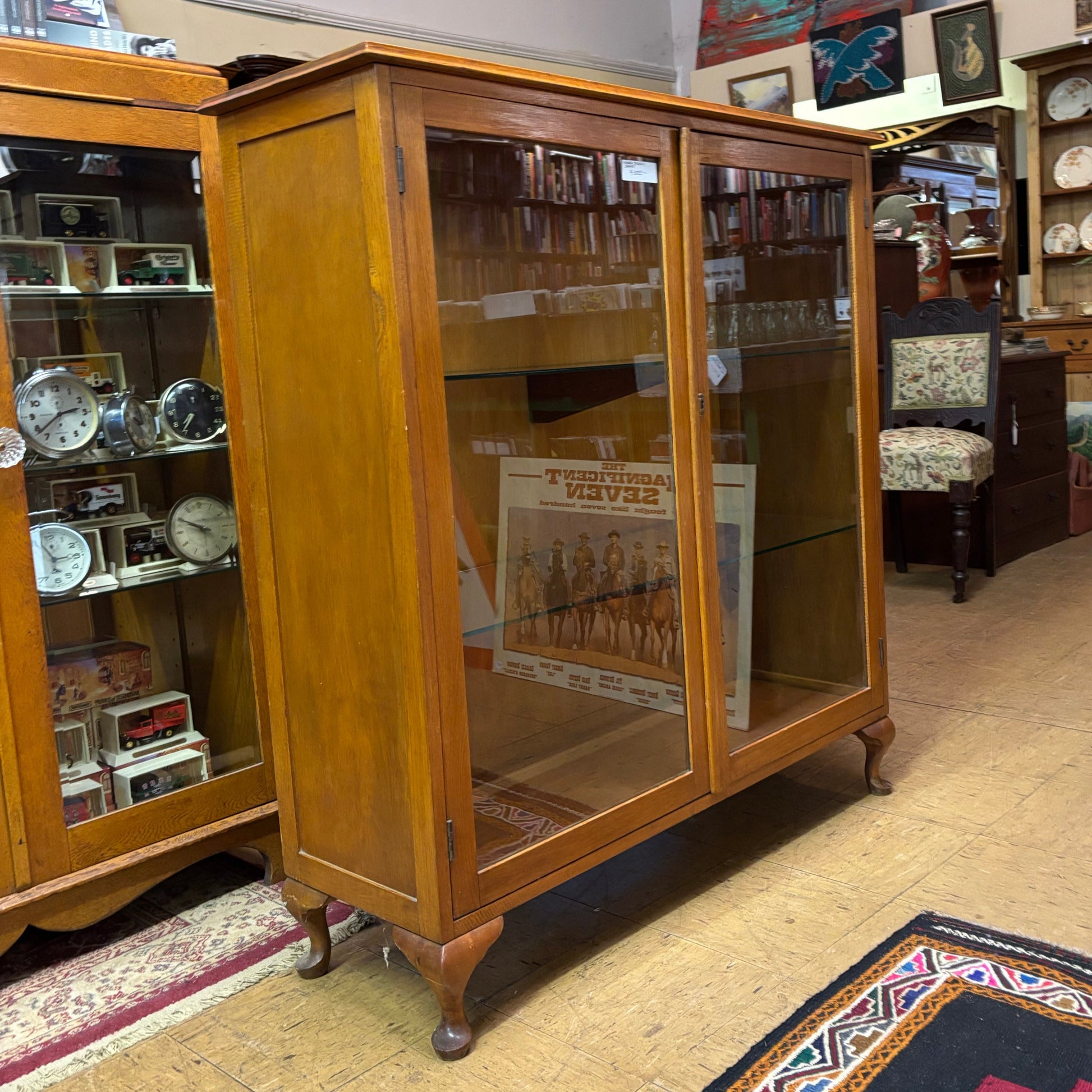 Wooden display cabinet with glass doors in an indoor setting