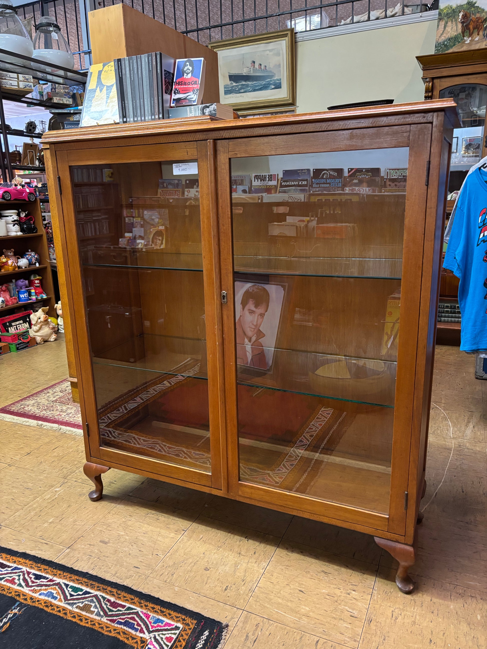 Wooden display case with glass panels on a wooden floor.