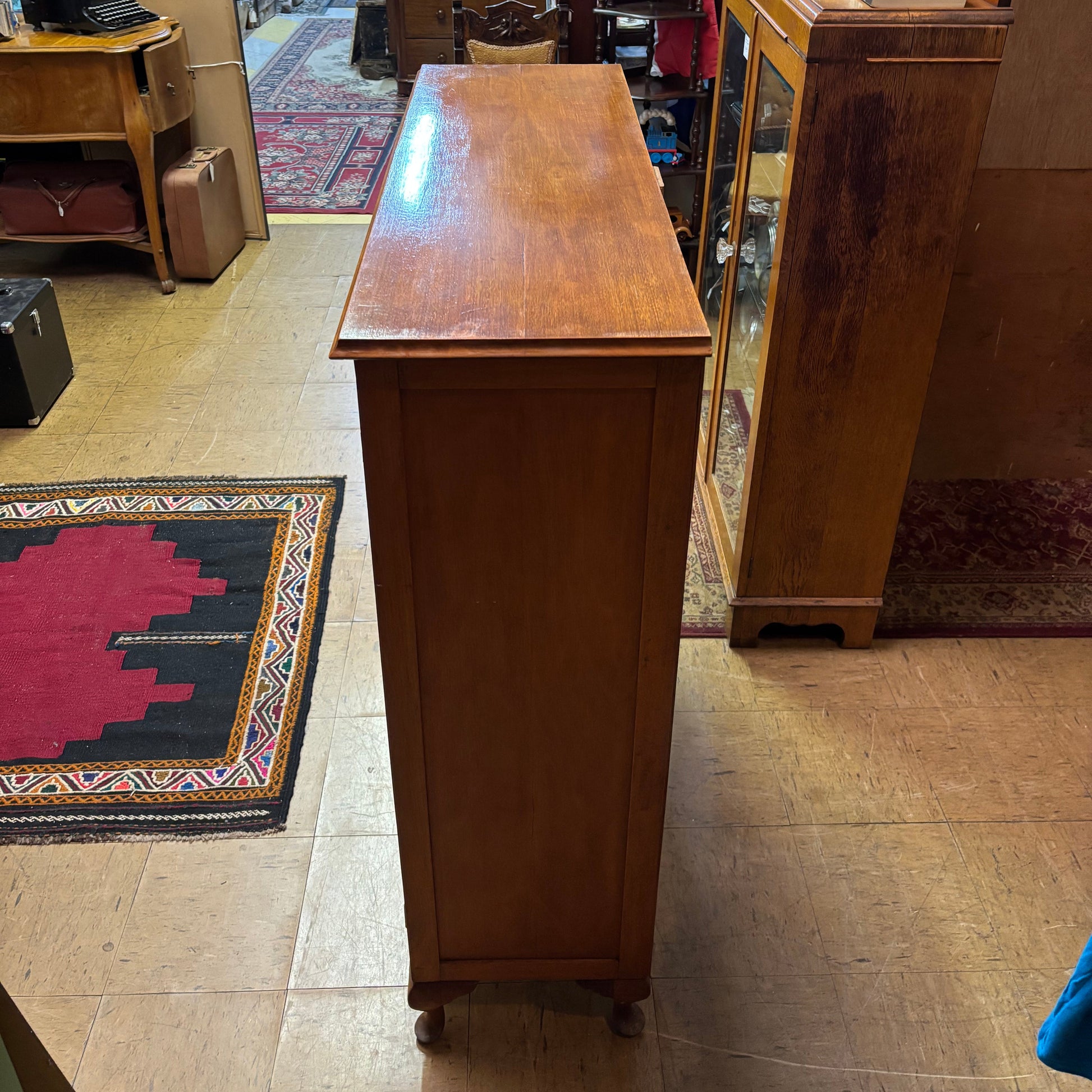 Wooden desk in a room with a mirror reflecting various items.