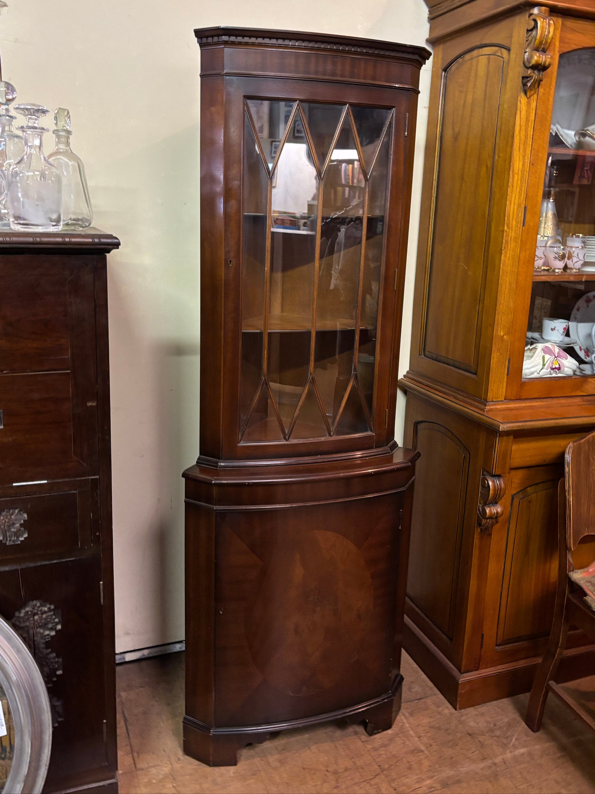 Wooden display cabinet with glass doors in a room setting