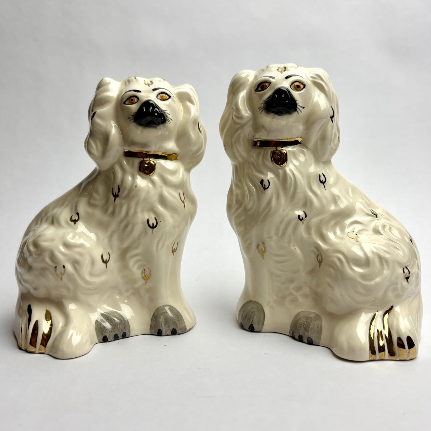 Two ceramic dog figurines on a light gray background