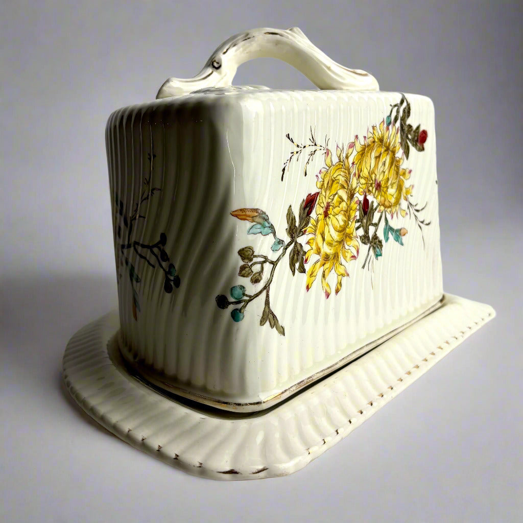 Ceramic butter dish with floral design on a gray background